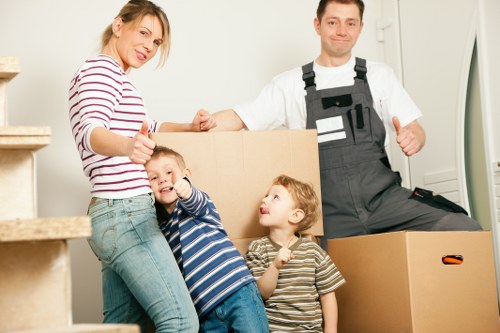 Professional movers carrying furniture through a flat stairwell in Wimbledon